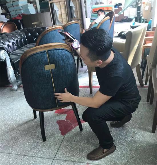 首席设计师李勤认真检查椅子的每一个部件，他经常说：“好产品就是要做好每一个细节”。